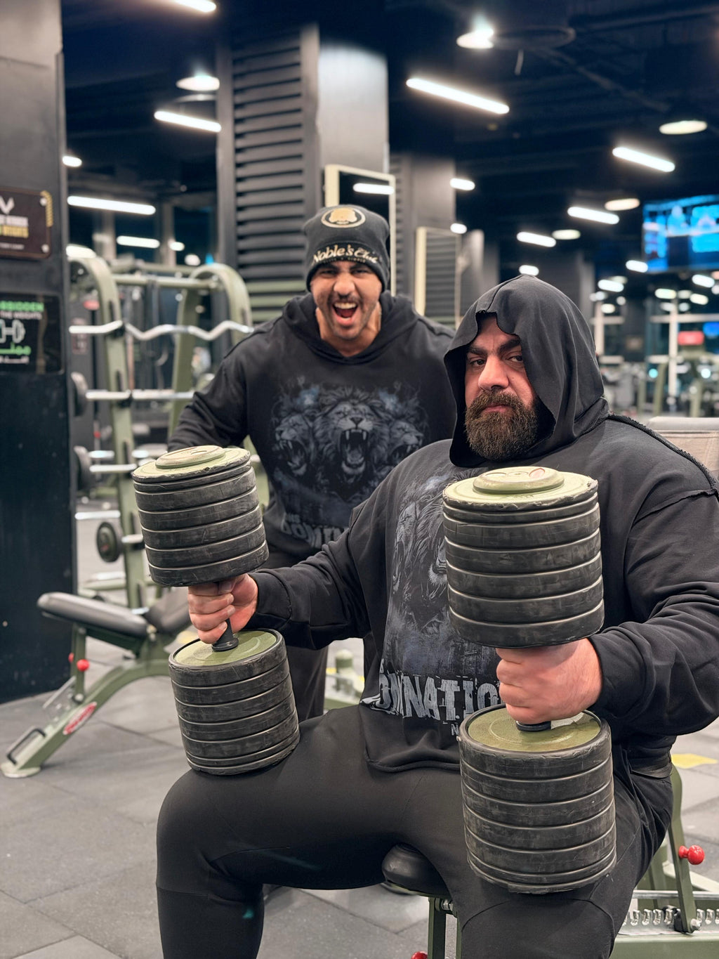 Two men lifting weights in a gym setting